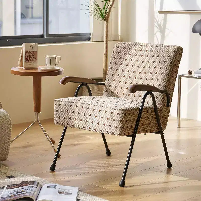Poltrona con schienale alto e braccioli, design ad ali e base a X in metallo